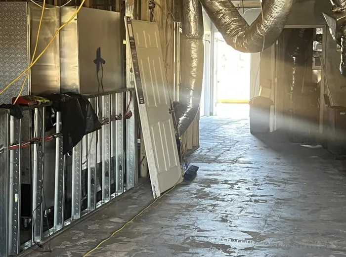 Interior corridor stripped to studs and concrete during a gut renovation