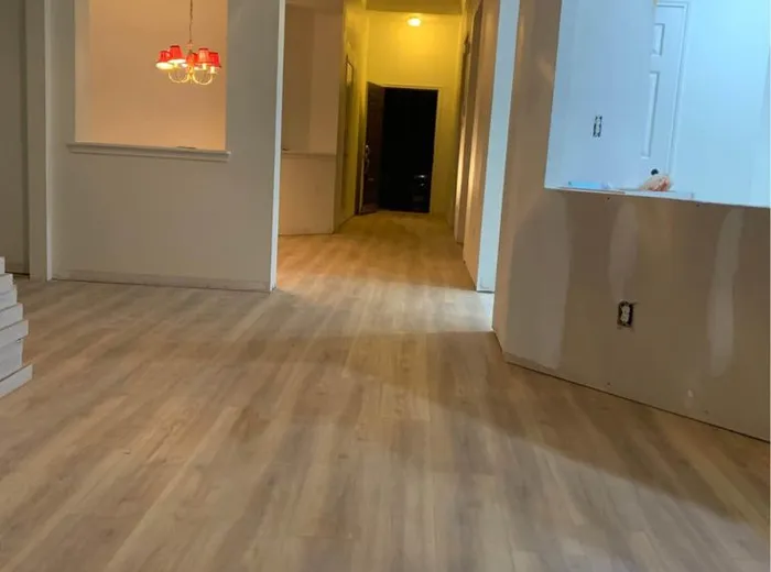 Newly installed wood-look flooring through an open living area and hallway